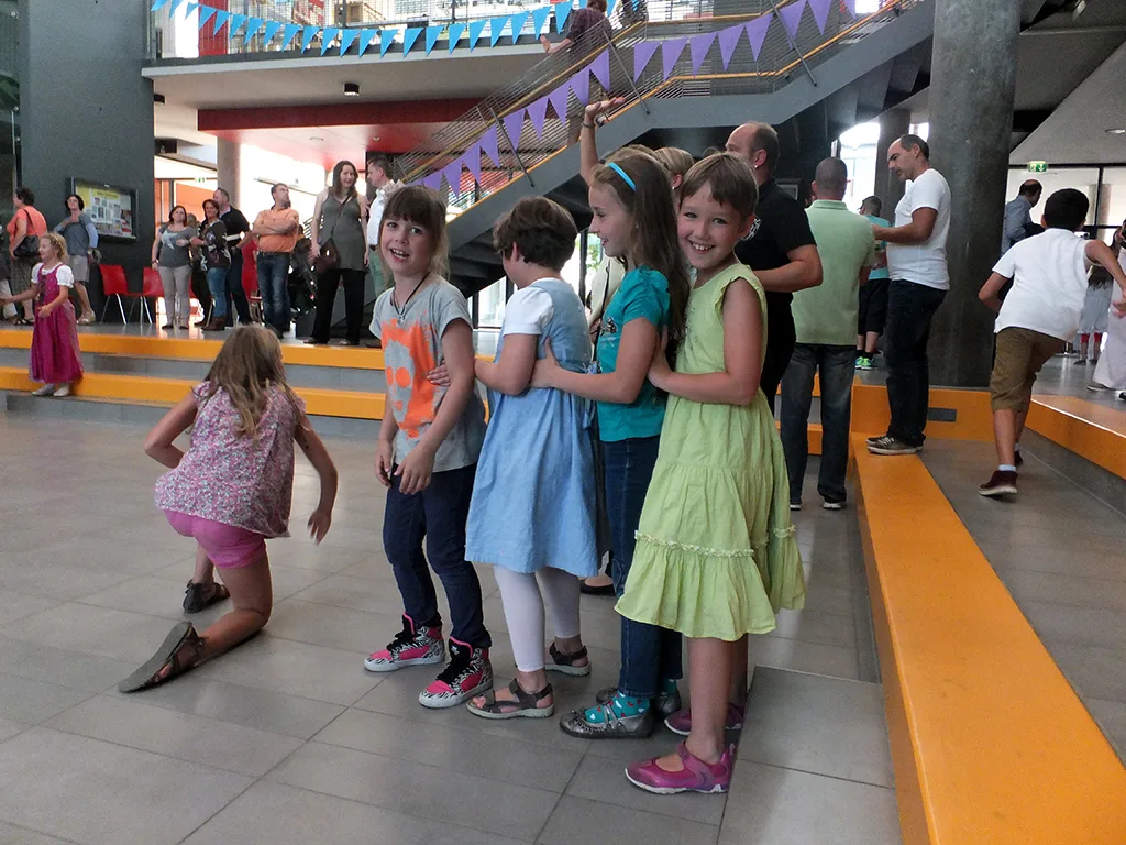 Kinder tanzen im Foyer im Kreis.